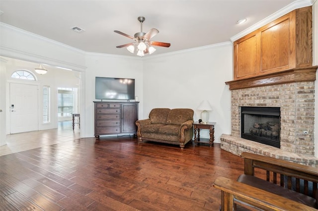 2632 SE 97th St, Moore, OK 73160 - living room featuring ceiling fan, crown molding, dark wood-type flooring, and a fireplace