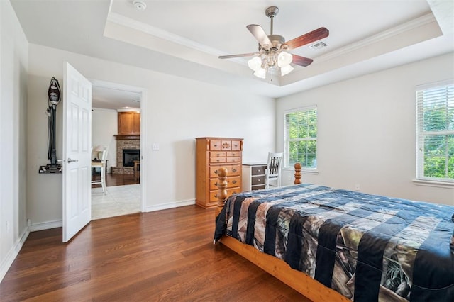 2632 SE 97th St, Moore, OK 73160 - bedroom with a raised ceiling, wood finished floors, a fireplace, ornamental molding, and baseboards
