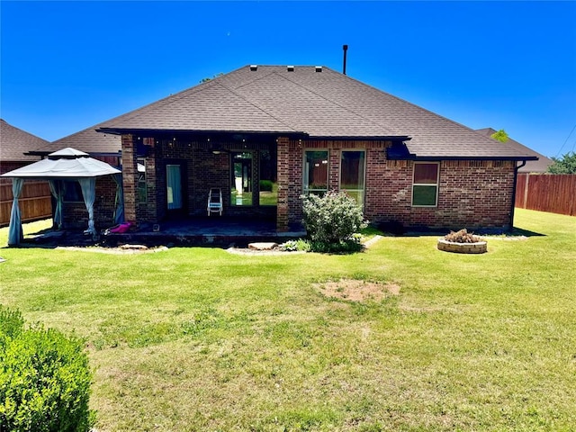 3001 Flint Ct, Oklahoma City, OK 73165 - rear view of house featuring a gazebo, brick siding, a patio area, an outdoor fire pit, and roof with shingles