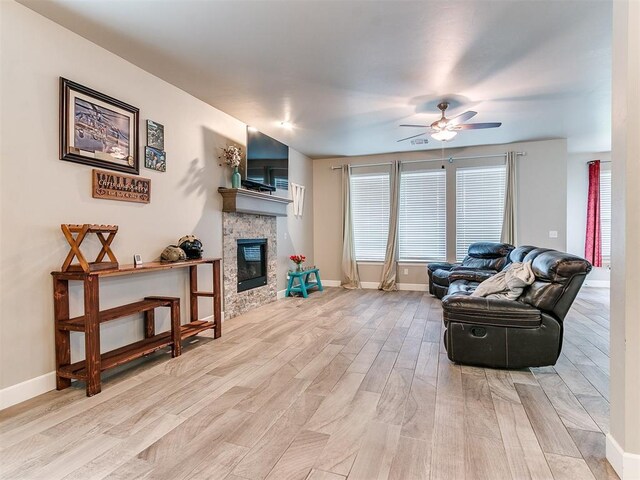 1405 Atalon Dr, Moore, OK 73160 - living area featuring light wood-style floors, ceiling fan, a stone fireplace, and baseboards