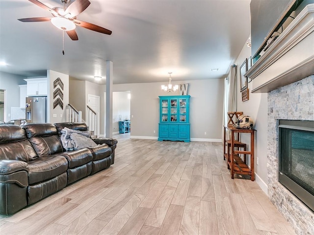 1405 Atalon Dr, Moore, OK 73160 - living area featuring ceiling fan, light wood-type flooring, stairs, a stone fireplace, and a chandelier