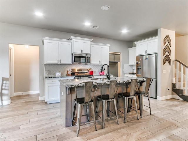 1405 Atalon Dr, Moore, OK 73160 - kitchen featuring appliances with stainless steel finishes, a sink, tasteful backsplash, light stone countertops, and recessed lighting
