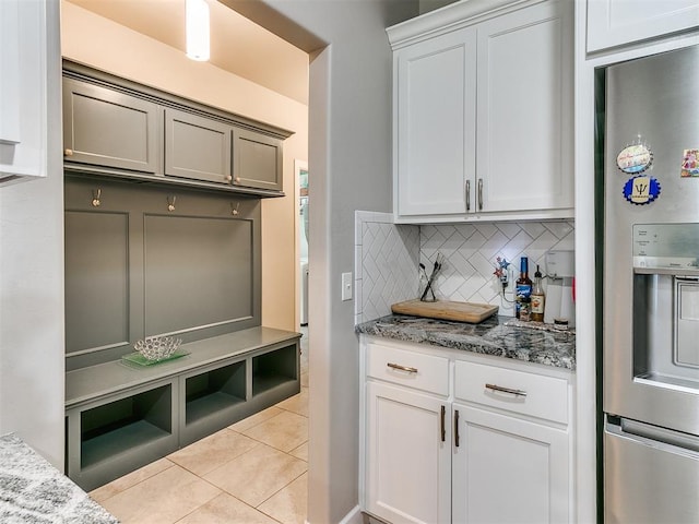 1405 Atalon Dr, Moore, OK 73160 - kitchen featuring stainless steel fridge, light tile patterned floors, backsplash, light stone countertops, and white cabinetry