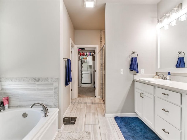 1405 Atalon Dr, Moore, OK 73160 - full bathroom featuring vanity, a bath, a spacious closet, baseboards, and washer / dryer