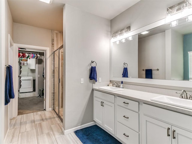 1405 Atalon Dr, Moore, OK 73160 - bathroom featuring washer / clothes dryer, double vanity, a spacious closet, and a stall shower