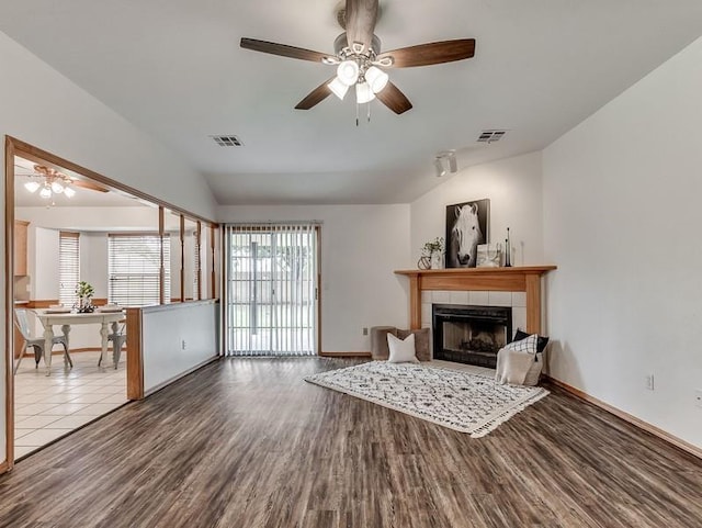 2121 NE 13th St, Moore, OK 73160 - living area with vaulted ceiling, a ceiling fan, wood finished floors, a tile fireplace, and baseboards