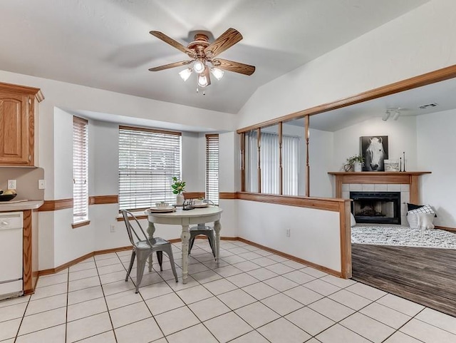 2121 NE 13th St, Moore, OK 73160 - dining space with ceiling fan, a fireplace, baseboards, vaulted ceiling, and light tile patterned floors