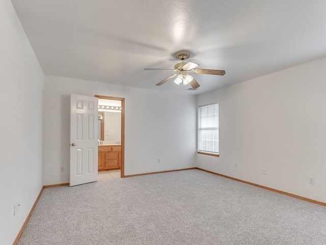 2121 NE 13th St, Moore, OK 73160 - unfurnished bedroom with light colored carpet, baseboards, connected bathroom, and ceiling fan