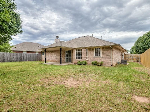 2121 NE 13th St, Moore, OK 73160 - back of house featuring a patio, brick siding, central AC unit, and a chimney