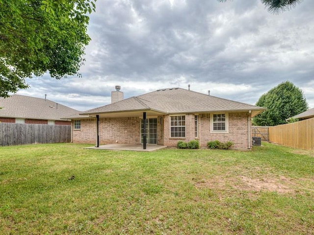 2121 NE 13th St, Moore, OK 73160 - rear view of property with a patio area, brick siding, a chimney, and central AC unit