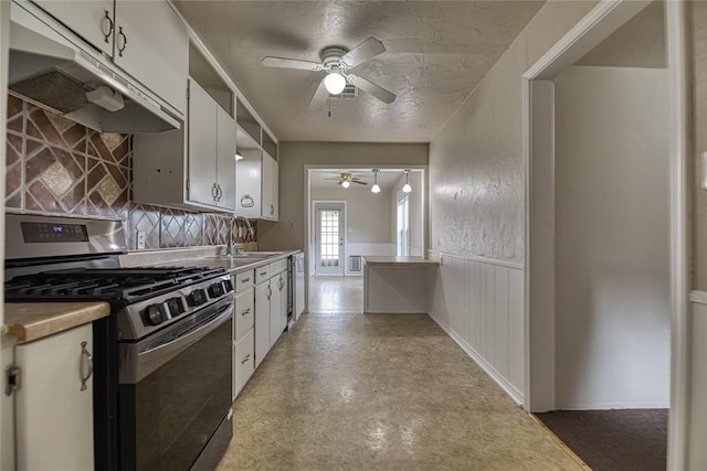 515 N Booth Ave, Elk City, OK 73644 - kitchen with stainless steel range with gas cooktop, ceiling fan, a sink, under cabinet range hood, and white cabinetry