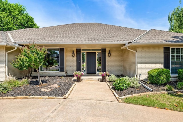 1704 Faircloud Dr, Edmond, OK 73034 - property entrance featuring roof with shingles, brick siding, and a porch