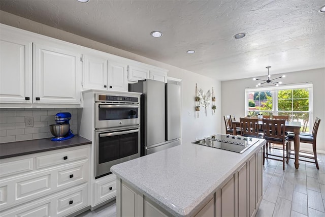 1704 Faircloud Dr, Edmond, OK 73034 - kitchen with appliances with stainless steel finishes, a kitchen island, a chandelier, backsplash, and recessed lighting