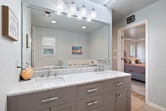 1704 Faircloud Dr, Edmond, OK 73034 - full bath featuring double vanity, healthy amount of natural light, ensuite bathroom, and wood finished floors