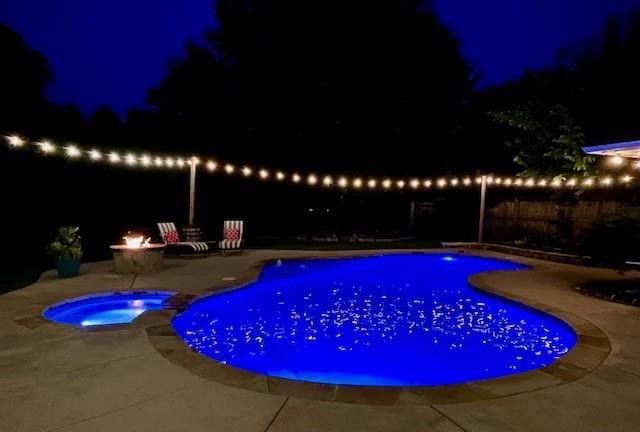 1704 Faircloud Dr, Edmond, OK 73034 - pool at twilight featuring an outdoor fire pit, a patio, a fenced backyard, and a pool with connected hot tub