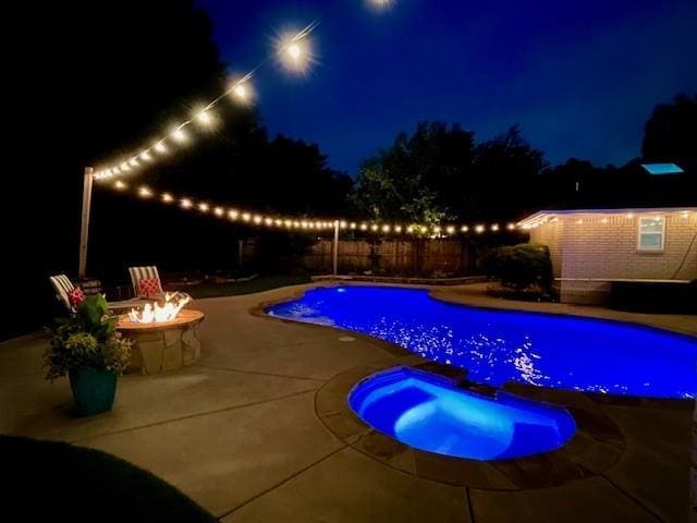 1704 Faircloud Dr, Edmond, OK 73034 - pool at twilight featuring an in-ground hot tub, an outdoor fire pit, a patio area, and a fenced backyard