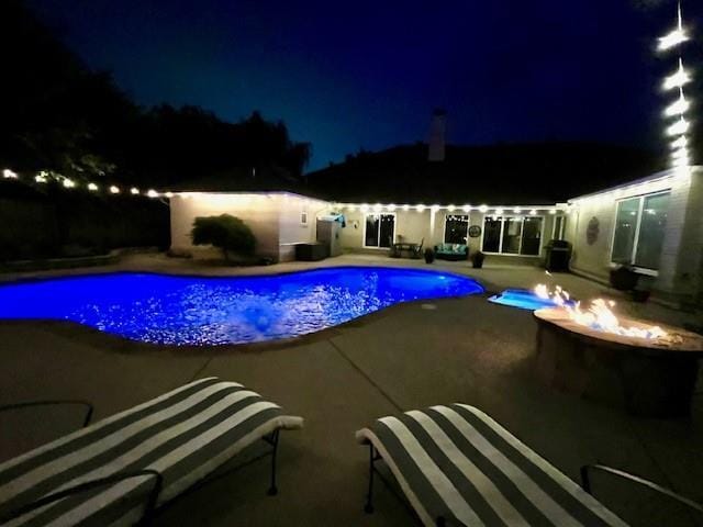 1704 Faircloud Dr, Edmond, OK 73034 - pool at twilight featuring a patio and a fire pit