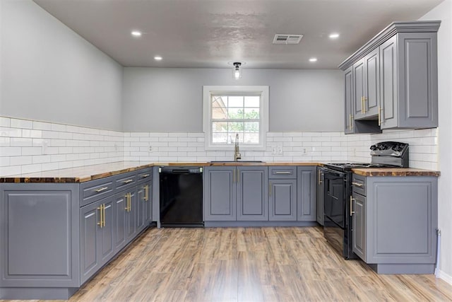 1206 Monroe Dr, Shawnee, OK 74804 - kitchen with black appliances, a sink, wood counters, gray cabinets, and recessed lighting