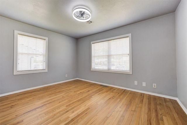 1206 Monroe Dr, Shawnee, OK 74804 - empty room featuring plenty of natural light, wood finished floors, and baseboards