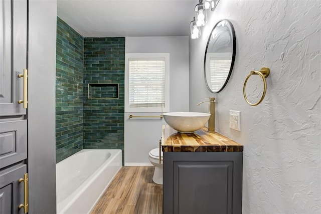 1206 Monroe Dr, Shawnee, OK 74804 - bathroom with vanity, wood finished floors, toilet, shower / washtub combination, and baseboards