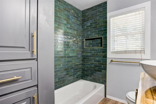 1206 Monroe Dr, Shawnee, OK 74804 - bathroom with toilet, wood finished floors, tub / shower combination, and baseboards