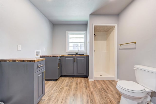 1206 Monroe Dr, Shawnee, OK 74804 - bathroom featuring wood finished floors, toilet, a shower stall, vanity, and baseboards