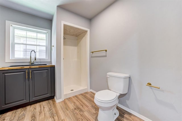 1206 Monroe Dr, Shawnee, OK 74804 - full bathroom featuring a sink, toilet, wood finished floors, baseboards, and a shower