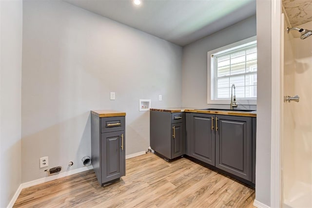 1206 Monroe Dr, Shawnee, OK 74804 - laundry room featuring cabinet space, light wood-type flooring, gas dryer hookup, washer hookup, and baseboards