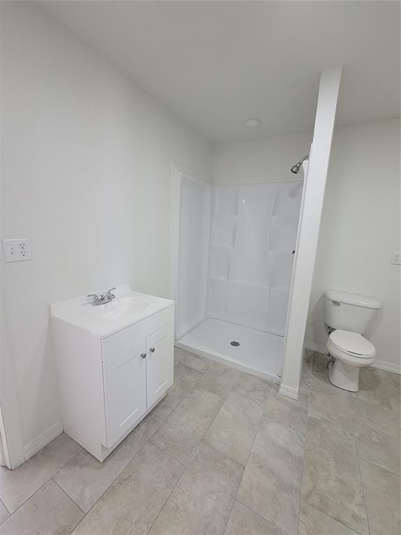 1228 Santa Fe Dr, Clinton, OK 73601 - bathroom featuring toilet, vanity, a shower, and baseboards