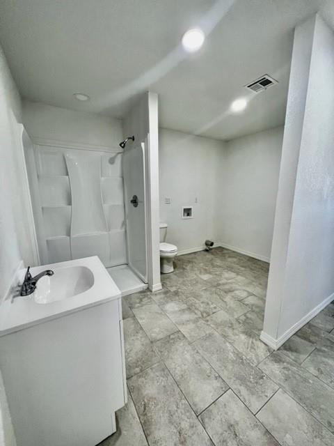 1228 Santa Fe Dr, Clinton, OK 73601 - full bathroom featuring toilet, a stall shower, vanity, baseboards, and recessed lighting