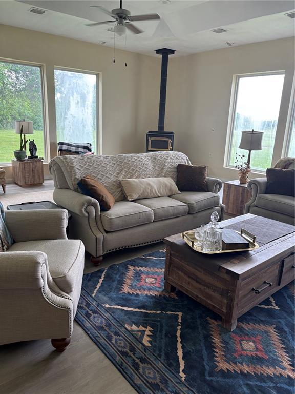 32629 S Airline Rd, Pauls Valley, OK 73075 - living room with a wood stove, a ceiling fan, and wood finished floors