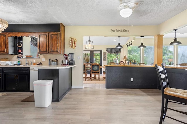 32629 S Airline Rd, Pauls Valley, OK 73075 - kitchen with a textured ceiling, light wood-style flooring, light countertops, a ceiling fan, and hanging light fixtures