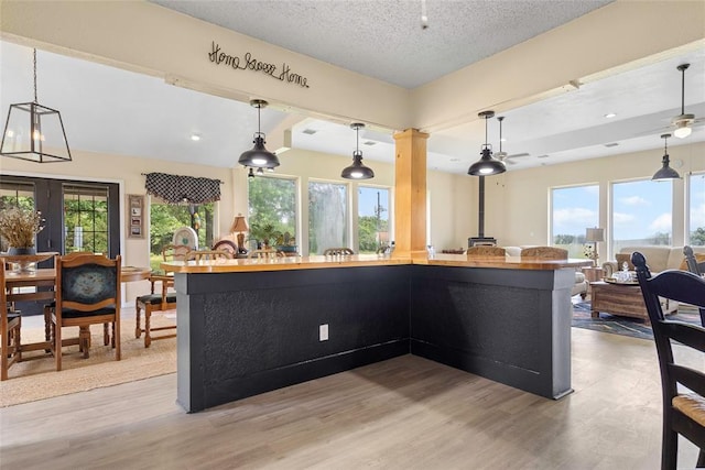 32629 S Airline Rd, Pauls Valley, OK 73075 - kitchen featuring light wood-type flooring, pendant lighting, open floor plan, a large island, and a textured ceiling
