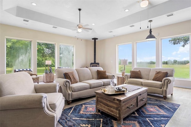 32629 S Airline Rd, Pauls Valley, OK 73075 - living area featuring a wood stove, ceiling fan, dark wood finished floors, recessed lighting, and a tray ceiling
