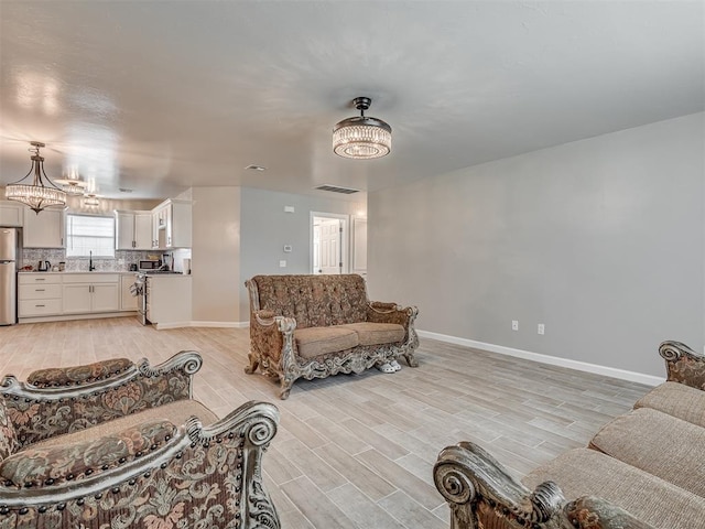 4100 S Noma Rd, Oklahoma City, OK 73150 - living area with light wood-style floors, baseboards, and a chandelier