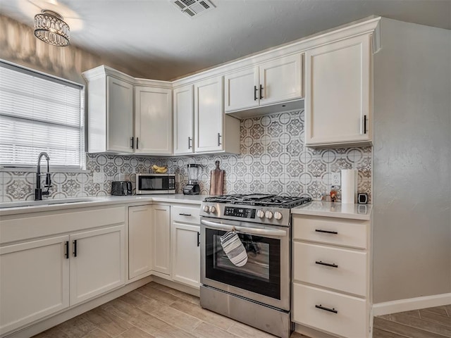 4100 S Noma Rd, Oklahoma City, OK 73150 - kitchen featuring stainless steel appliances, a sink, light countertops, light wood finished floors, and tasteful backsplash