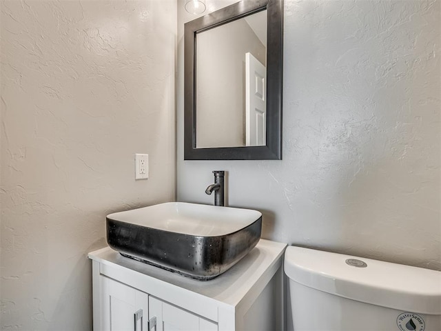 4100 S Noma Rd, Oklahoma City, OK 73150 - half bathroom featuring vanity, toilet, and a textured wall