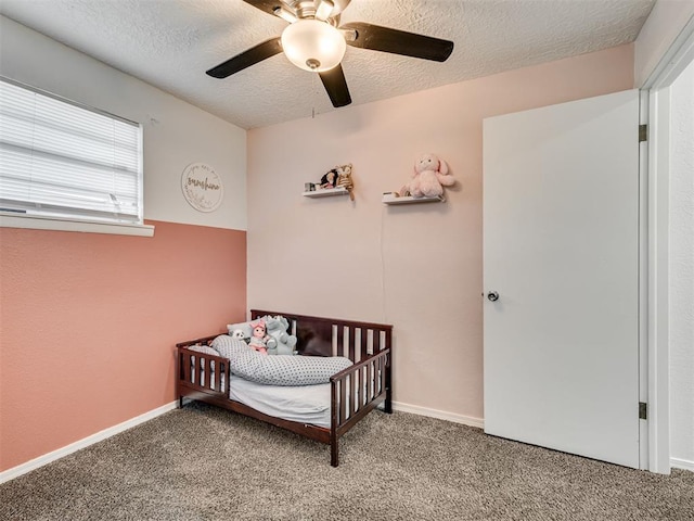 303 W Meek St, Wayne, OK 73095 - bedroom with carpet, a nursery area, a textured ceiling, a ceiling fan, and baseboards