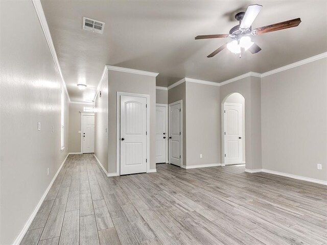 8344 NW 137th St, Oklahoma City, OK 73142 - empty room featuring light wood-style floors, a ceiling fan, crown molding, baseboards, and arched walkways
