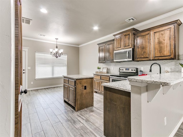 8344 NW 137th St, Oklahoma City, OK 73142 - kitchen with appliances with stainless steel finishes, baseboards, decorative backsplash, a peninsula, and ornamental molding
