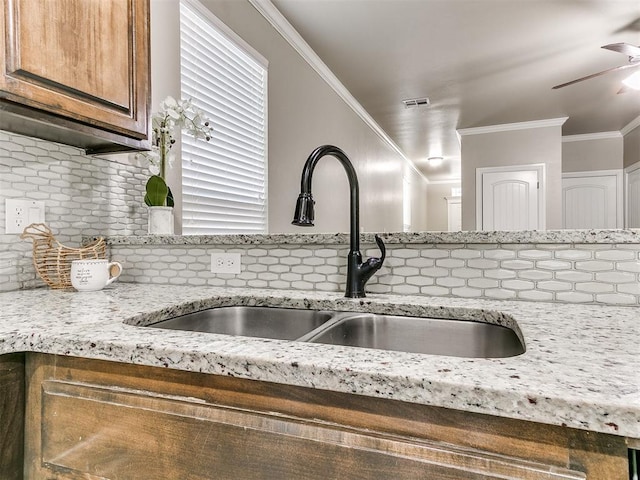 8344 NW 137th St, Oklahoma City, OK 73142 - kitchen view of a sink, decorative backsplash, ornamental molding, a ceiling fan, and light stone countertops