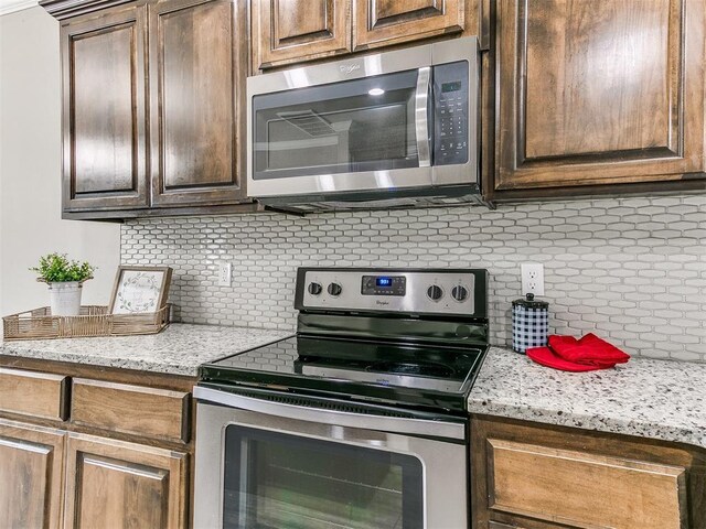 8344 NW 137th St, Oklahoma City, OK 73142 - kitchen with appliances with stainless steel finishes, tasteful backsplash, and dark brown cabinets