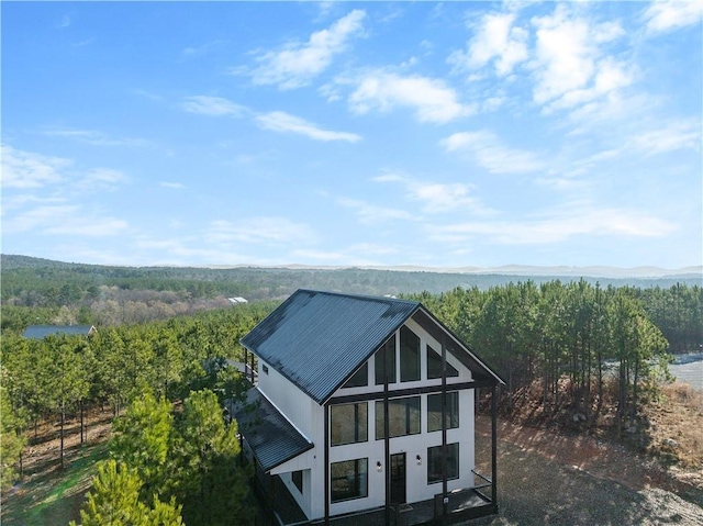 72 Green Persimmon Trl, Broken Bow, OK 74728 - rear view of property with a wooded view, metal roof, and stucco siding