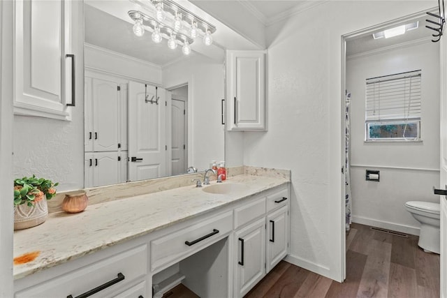 1206 N Kaiser Rd, Weatherford, OK 73096 - bathroom featuring vanity, toilet, wood finished floors, crown molding, and baseboards