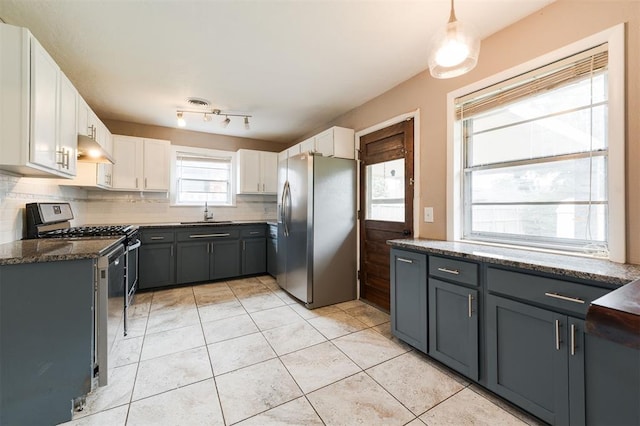 3901 NW 56th Pl, Oklahoma City, OK 73112 - kitchen with stainless steel appliances, ventilation hood, a sink, backsplash, and white cabinets