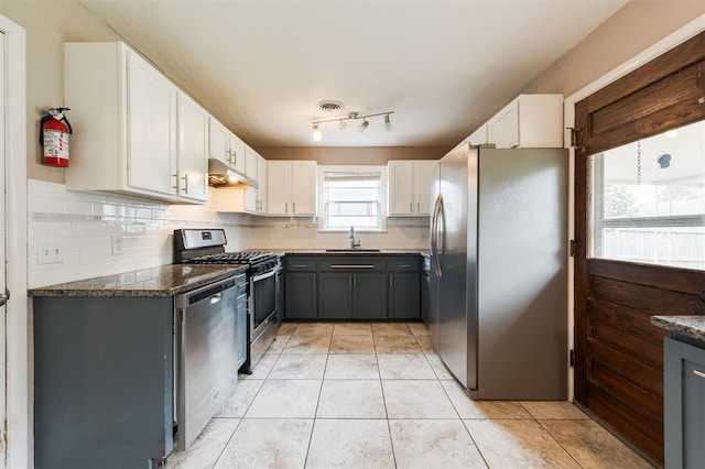 3901 NW 56th Pl, Oklahoma City, OK 73112 - kitchen with stainless steel appliances, a sink, decorative backsplash, under cabinet range hood, and white cabinets