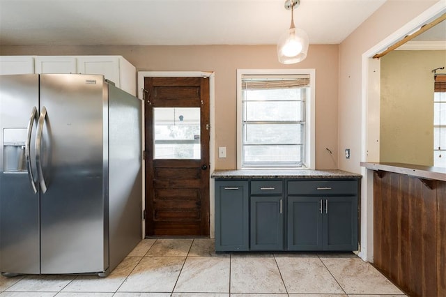 3901 NW 56th Pl, Oklahoma City, OK 73112 - kitchen with stainless steel refrigerator with ice dispenser, light tile patterned floors, white cabinets, and pendant lighting