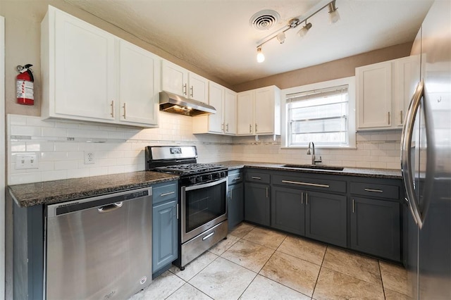 3901 NW 56th Pl, Oklahoma City, OK 73112 - kitchen featuring stainless steel appliances, under cabinet range hood, a sink, and white cabinetry