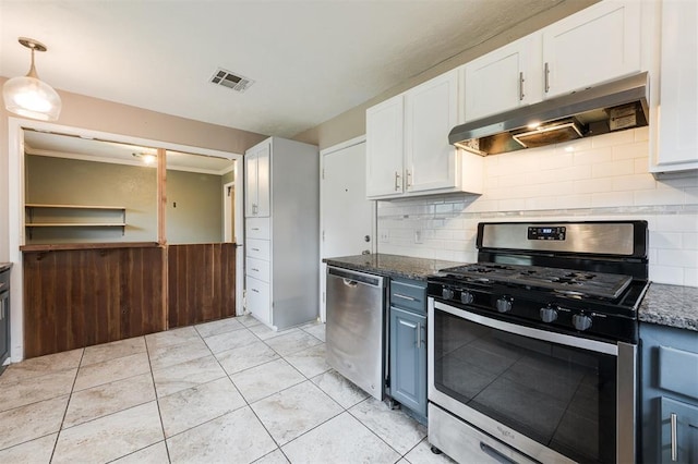 3901 NW 56th Pl, Oklahoma City, OK 73112 - kitchen with stainless steel appliances, under cabinet range hood, white cabinetry, a wainscoted wall, and decorative backsplash