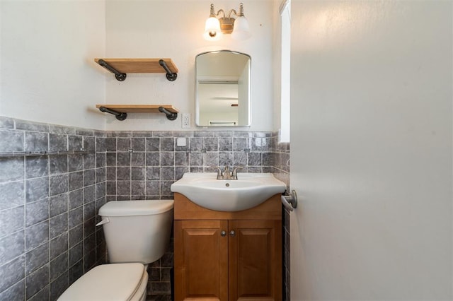 3901 NW 56th Pl, Oklahoma City, OK 73112 - half bathroom with toilet, vanity, tile walls, and wainscoting